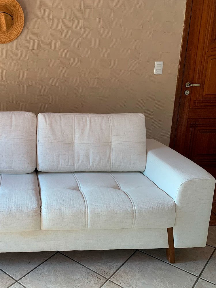 Sofá limpo após processo de higienização profissional, com aparência renovada e tecido conservado.
